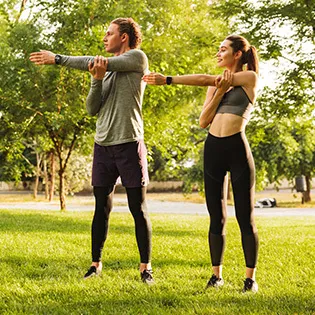 men and women exercising in park